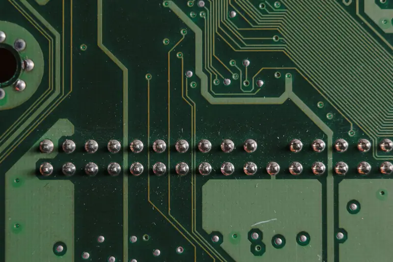 Underside of a circuit board with rows of through-hole solder joints